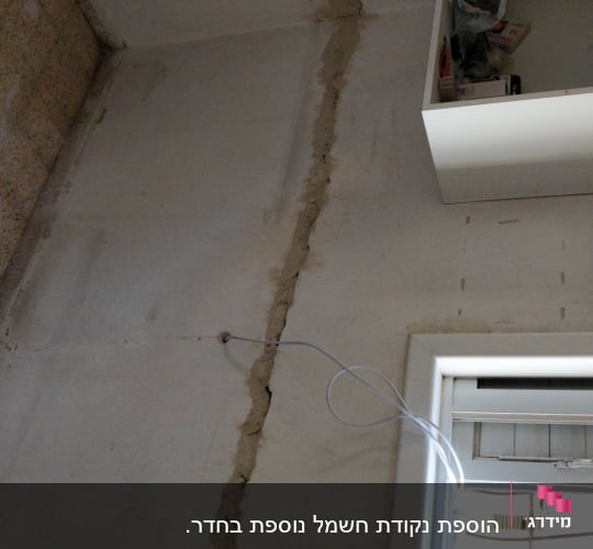 שקע חשמל על קיר עם חוטים חשופים